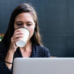kobieta z kawą przy laptopie