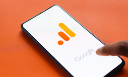 Na pomarańczowym tle, włączony telefon z logo Google Analytics 4.