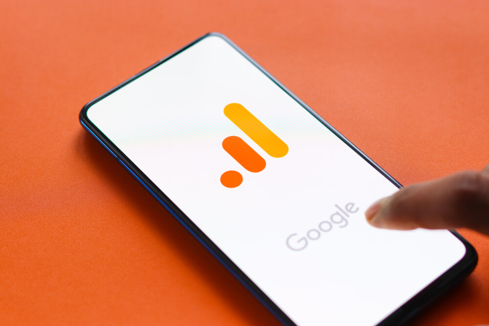 Na pomarańczowym tle, włączony telefon z logo Google Analytics 4.
