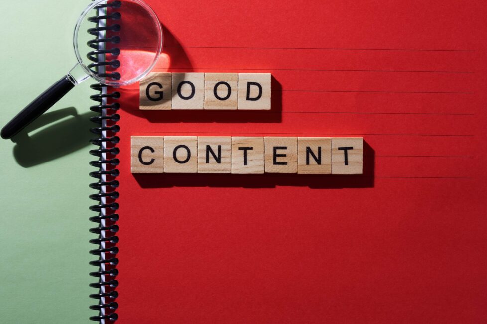 napis good content marketing ułożony z drewnianych liter na czerwono-zielonym tle